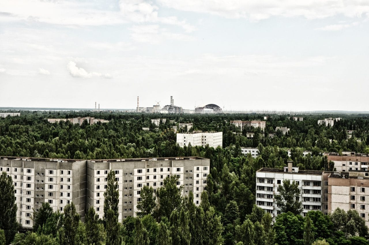 Vista aérea de Pripyat en Ucrania, con la abandonada central nuclear de Chernóbil dominando el horizonte entre edificios y naturaleza.
