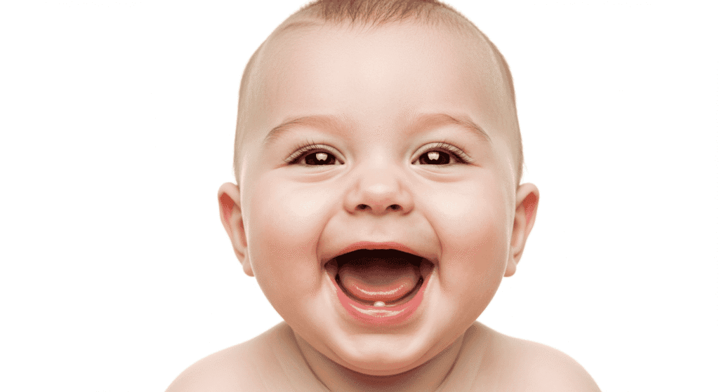 Bebé sonriendo con los ojos cerrados. Primer plano de cara infantil con expresión divertida. Diente de leche visible. Alegría infantil.