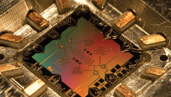 Computación Cuántica en Palabras Simples: Cómo Funciona y por Qué Importa 5 Circuito cuántico: imagen detallada de un chip de computación cuántica con diseño complejo y colores iridiscentes. Accesibilidad web para personas con discapacidad visual y optimización SEO.