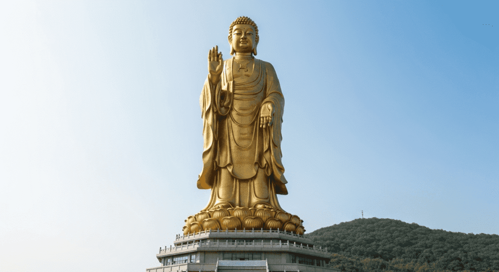 Las estatuas más altas del mundo: monumentos que impresionan 5 Enorme estatua dorada de Buda en China, elevándose contra un cielo azul claro. Monumento religioso budista en zona natural