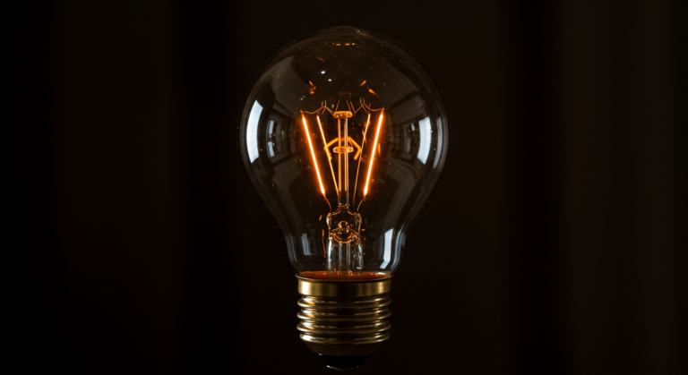 Bombilla incandescente iluminada sobre fondo oscuro. Imagen que simboliza una idea brillante o la energía eléctrica. Ideal para contenido sobre innovación, iluminación y tecnología.
