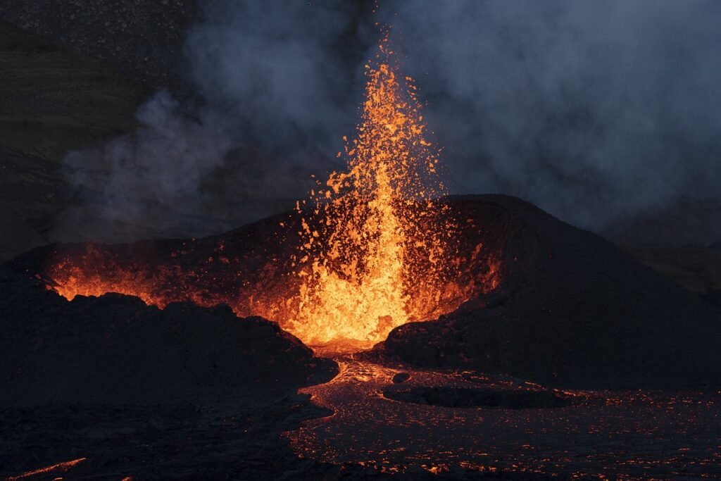 Hipótesis Gaia: ¿Es la Tierra un Ser Vivo? 4 Erupción volcánica nocturna con lava incandescente y humo.