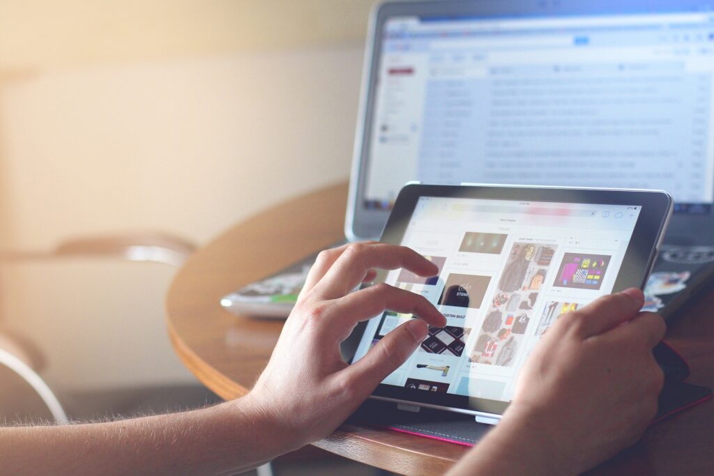 El acceso a internet como Derecho Humano 1 Persona usando una tablet para navegar por internet, con un portátil de fondo.