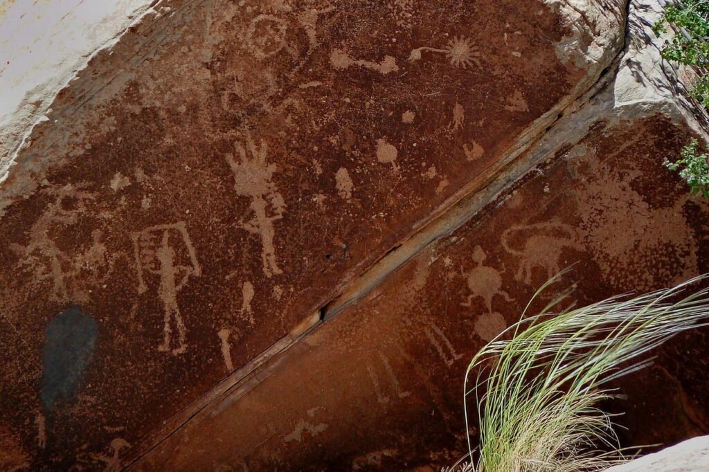 La evolución de la comunicación humana 1 Petroglifos tallados en roca, mostrando figuras humanas y animales, utilizados por antiguas civilizaciones para registrar y comunicar ideas