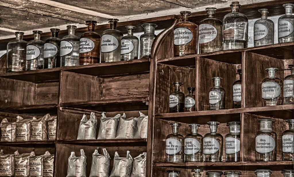 El poder de las plantas medicinales en la historia 5 Estantería antigua llena de frascos de vidrio etiquetados, utilizados para almacenar remedios y compuestos medicinales, evocando el estilo de una farmacia tradicional.
