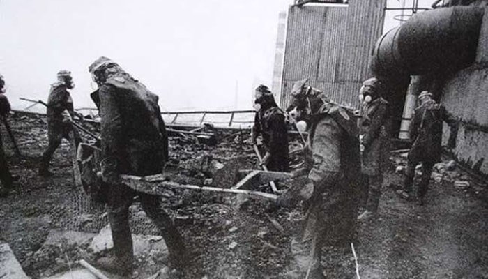 Chernóbil: La Tragedia Nuclear Que Marcó al Mundo 5 Fotografía en blanco y negro de los liquidadores de Chernóbil trabajando entre escombros radiactivos, mostrando el peligro y la magnitud de la limpieza tras el desastre nuclear.