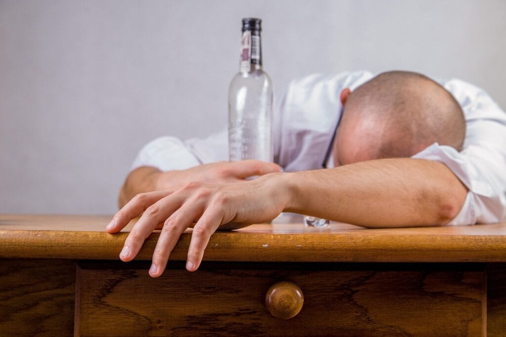 ¿Por Qué el Alcohol Nos Hace Perder la Memoria? 3 Persona inconsciente por abuso de alcohol. Imagen de embriaguez y riesgos para la salud.
