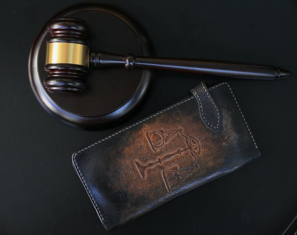 Pena de Muerte: Orígenes, Métodos y su Impacto en la Sociedad 4 Primer plano de un mazo de madera con detalles dorados y un estuche de cuero con símbolos legales grabados. Representación de la autoridad y tradición en la justicia.