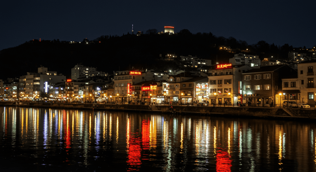 Normas insólitas: Las leyes más absurdas que siguen vigentes 7 Paisaje urbano nocturno con edificios iluminados reflejados en un río. Ciudad, noche, reflejos, iluminación, río urbano, arquitectura nocturna.