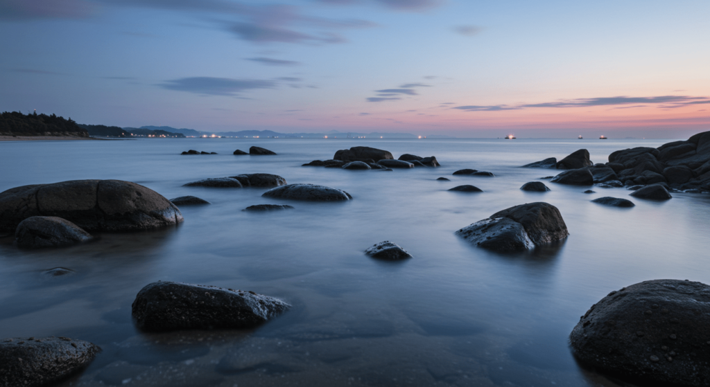 ¿Qué sucedería si la Tierra se quedara sin oxígeno durante 5 segundos? 7 Paisaje costero con rocas y agua neblinosa al atardecer. Vista tranquila de la costa con cielo azul y rosa. Fotografía de paisaje marítimo.