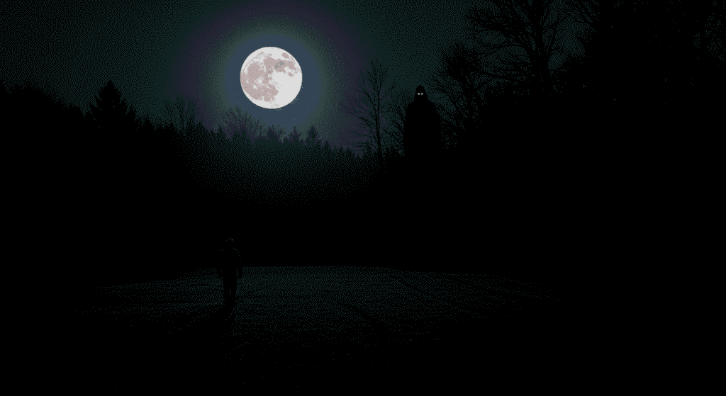 ¿Existen los fantasmas? Esto es lo que dice la ciencia 5 Imagen oscura de noche con luna llena y figura amenazante en el bosque, persona caminando en la distancia. Ideal para contenido de terror, suspense y fenómenos paranormales.