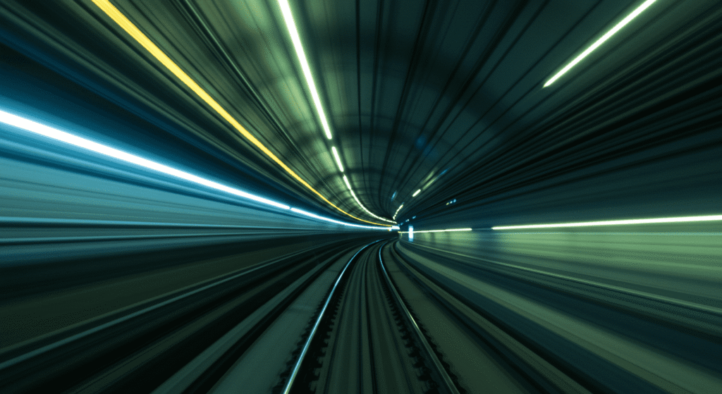 ¿Podemos Viajar a la Velocidad de la Luz? Lo Que Dice la Ciencia 5 Vista abstracta dentro de un túnel de metro con luces y colores brillantes, representando velocidad y movimiento.
