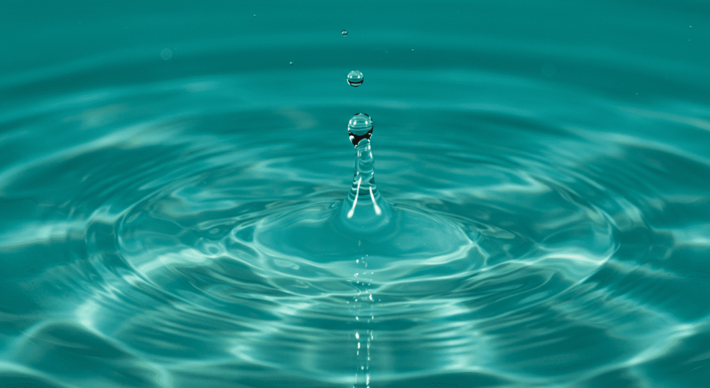 El gato de Schrödinger: ¿Vivo, muerto o ambas? La paradoja cuántica más famosa 3 "Fotografía de una gota de agua cayendo y creando ondas. Imagen de primer plano con agua turquesa y círculos concéntricos. Naturaleza y ciencia, dinámica de fluidos."