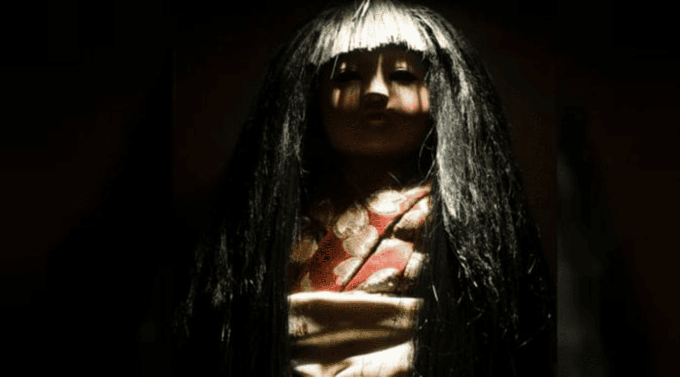 Muñecos poseídos: 5 historias reales tan aterradoras que parecen ficción 6 Muñeca japonesa de terror con pelo largo negro. Imagen oscura de juguete tradicional. Fotografía para accesibilidad y posicionamiento SEO.