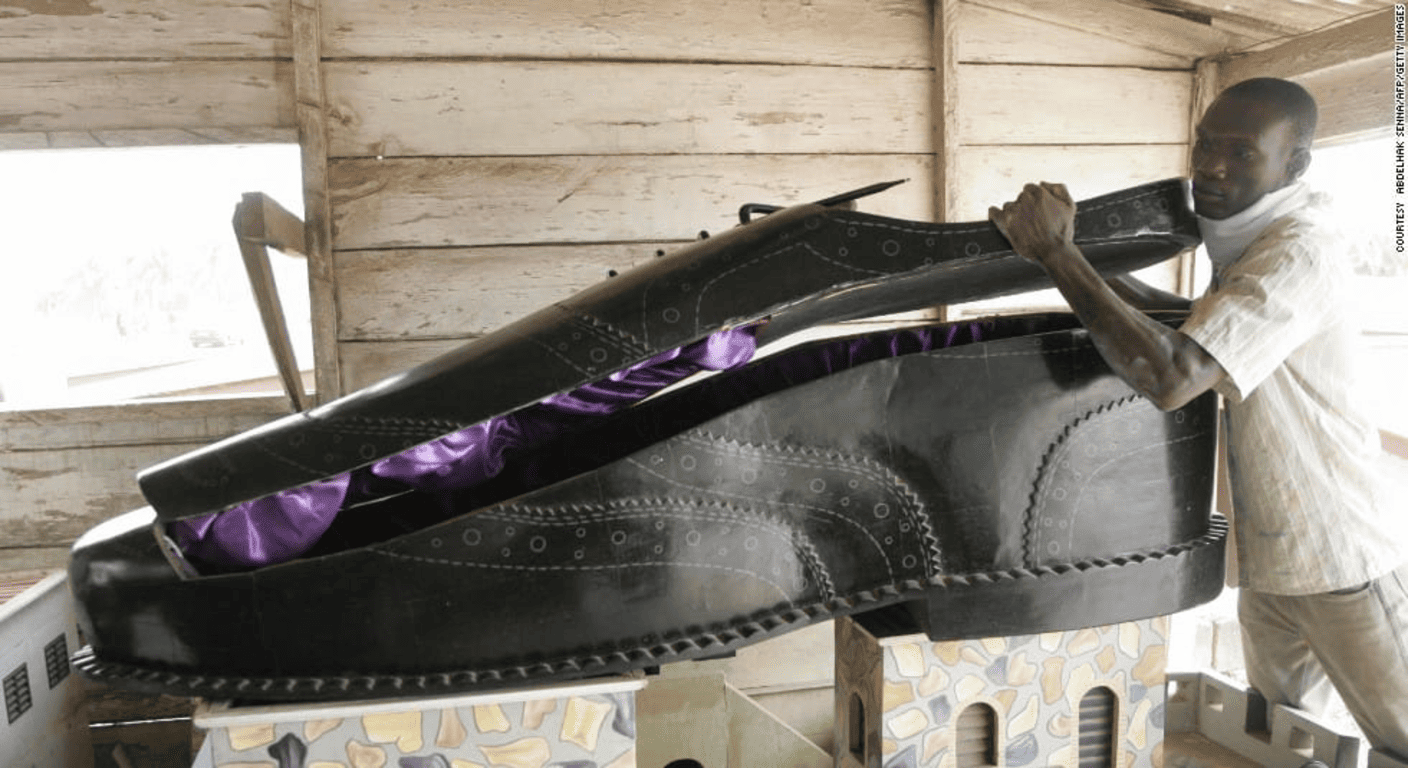 Los ritos funerarios más extraños del mundo: costumbres que sorprenden 2 Ataúd con forma de zapato en Ghana, reflejo de arte funerario africano. Expresión cultural en ritos funerarios, ideal para temas de viajes, arte y costumbres. Accesible para personas con discapacidad visual.