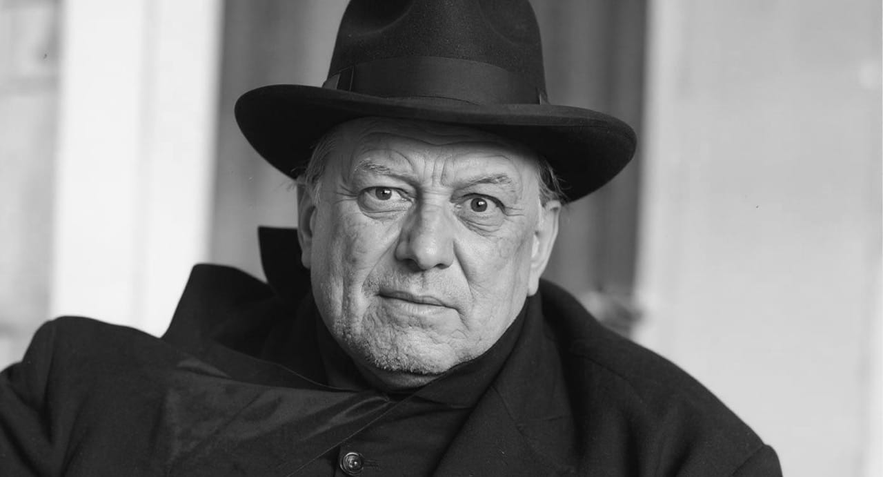 Aleister Crowley con túnica ceremonial y símbolos ocultistas, en una pose solemne representando su rol como mago y fundador de Thelema